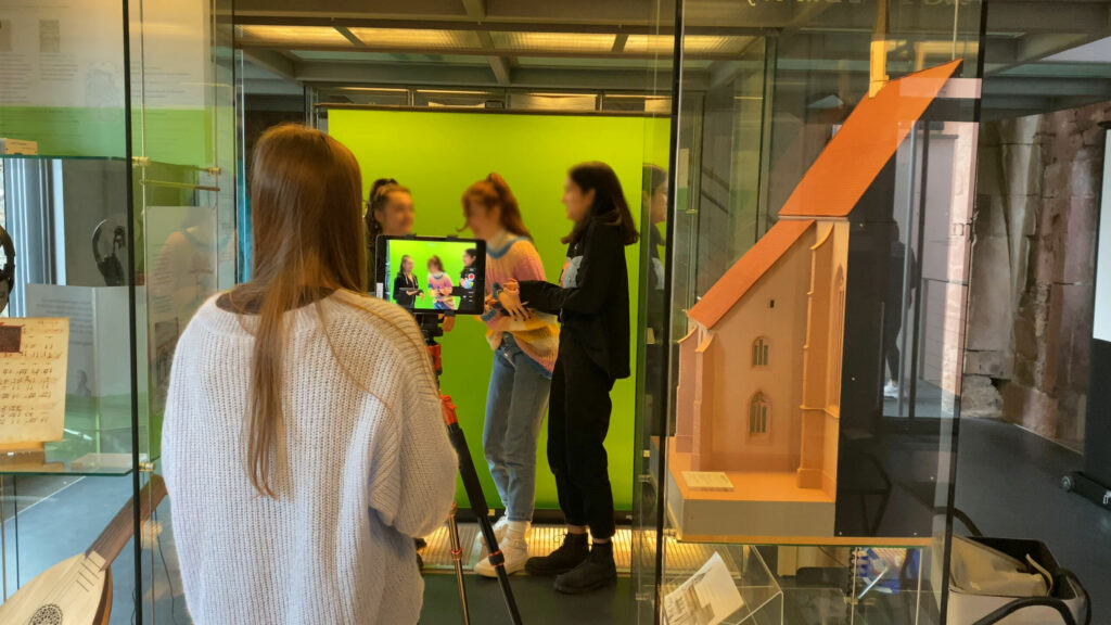 Schüler:innen filmen im Museum Johannes Reuchlin vor einem Greenscreen